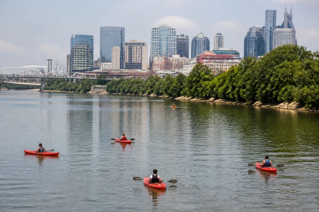 Kayakers touring the Cumberland River beside downtown Nashville