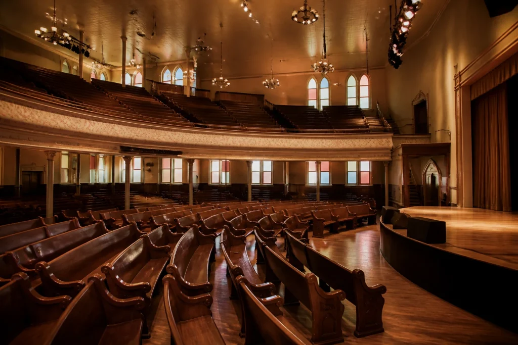 Historic wooden pews, balcony, and stage inside Ryman Auditorium in Nashville